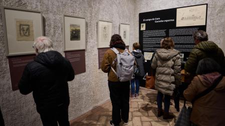 Varias personas contemplan las obras realizadas por artistas internados en el Campo de Gurs. La muestra se puede visitar en el patio del Condestable