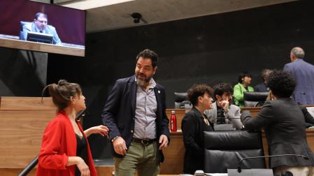 El secretario de organización del PSn, Ramón Alzórriz, conversa con la vicepresidenta Begoña Alfaro (Contigo). Arriba, a la derecha, los parlamentarios Adolfo Araiz y Laura Aznal (EH bildu)