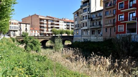 Vista del cauce del río Cidacos, completamente cubierto, con el puente al fondo