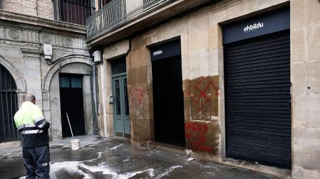 Un operario limpia unas pintadas aparecidas en la mañana de este jueves en la sede de EH Bildu en Pamplona