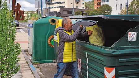 Una persona deposita una bolsa de basura en un contenedor de Tafalla