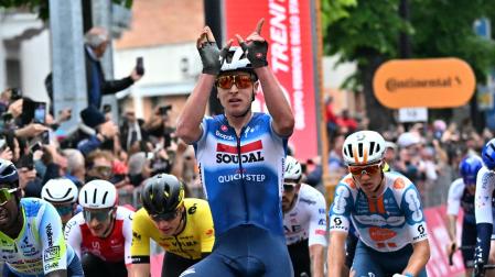Tim Merlier alza los brazos en la meta de Fossano