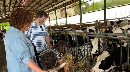 Unax, junto a su familia, da de comer a las vacas de Lacturale, lufar donde se ha presentado la iniciativa.