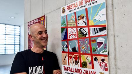 Ion Kepa Solchaga sonríe mirando su cartel, el que anunciará las próximas fiestas