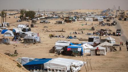 Los palestinos desplazados se preparan para salir con sus pocas pertenencias después de una orden de evacuación emitida por el ejército israelí, cerca de la frontera egipcia en Rafah, al sur de la Franja de Gaza