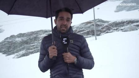 El exciclista Alberto Contador realiza una conexión para el canal Eurosport bajo una intensa nevada antes de la salida de la etapa del Giro de este martes
