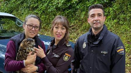 Agentes de Policía Nacional y una responsable del Centro de interpretación de la naturaleza de Urdax, con el búho real recuperado