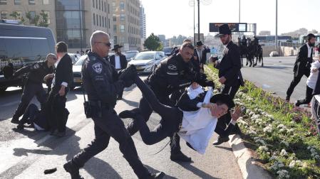 La policía expulsa a varios judíos ultraortodoxos en una protesta contra el reclutamiento militar obligatorio, frente a la Corta Suprema, en Jerusalén