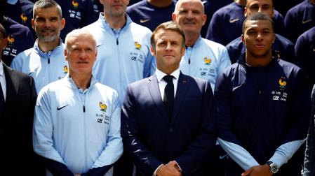 De izda. a dcha., en la primera fila, Didier Deschamps, Emmanuel Macron y Kylian Mbappé durante la visita de la selección francesa al presidente galo