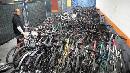 Un operario, junto a decenas de bicicletas que se encuentran almacenadas tras ser recogidas en la calle