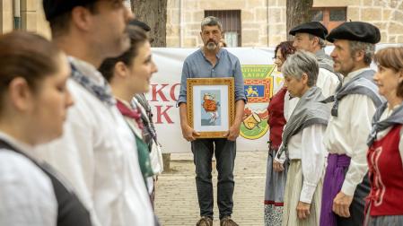 Fernando Hualde, con el galardón, frente a los dantzaris de Muthiko Alaiak.