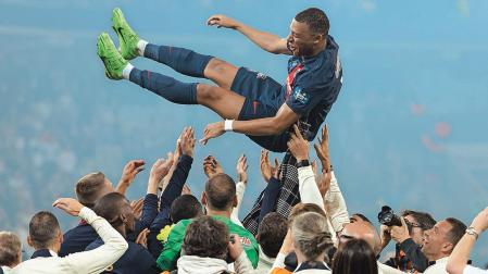 Mbappé manteado por sus compañeros del PSG en el último partido de la liga francesa en Lyon