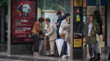 Las marquesinas han sido improvisados refugios este jueves para protegerse de la lluvia