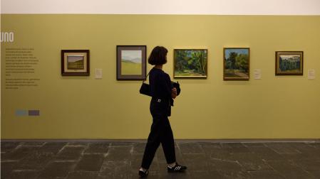 Una visitante contempla el conjunto de obras reunidas en la “tertulia” de pintoras titulada Fauno