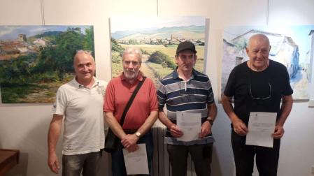 Ganadores del concurso de pintura de Urroz-Villa, con sus obras. De izda. a dcha., el concejal Ricardo Ainzúa Bernal y los tres premiados: Félix Flamarique, Jokin Tellería y Jean Jacques Dagua