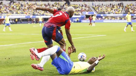 Vinícius Junior por los suelos tras perder un balón con el defensa de Costa Rica Jeyland Mitchell