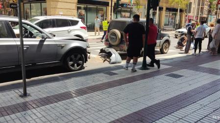 Los dos vehículos implicados y la mujer, sobre el suelo, tras el atropello