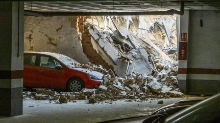 El desplome de un edificio en el barrio de Triana deja varios automóviles aparcados en un parking próximo con desperfectos