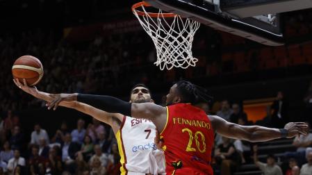 El escolta de la selección española, Santiago Aldama, trata de encestar ante la oposición del pívot de Angola, Bruno Fernando (d)
