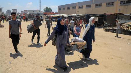 Varios refugiados caminan con sus pertenencias en la localidad de Khan Younis