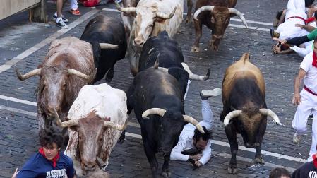 Los mozos corren junto a los morlacos de La Palmosilla en el tramo de la Plaza del Ayuntamiento durante el primer encierro de los Sanfermines 2024