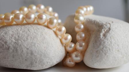 Un collar de perlas acomodado en una piedra