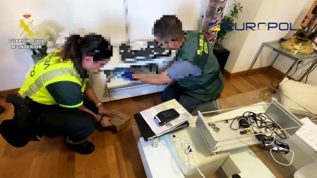 Dos agentes de la Guardia Civil inspeccionan la documentación incautada durante la operación