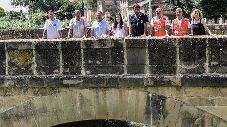 Desde la izda., Iñaki Sanz y su padre, José Antonio Sanz, de Aldo Deportes; Jesús Arrizubieta, ex alcalde de Tafalla; Natalia Roncal, de Viajes Zubia; Diego Ciérvide, responsable del GrupoScout Ibaialde; Javier Ongay, responsable de socorro y emergencias de Cruz Roja Tafalla; Manuel Musgo, presidente de Cruz Roja Tafalla; y Alicia Lizasoáin, de Aldo Deportes, en el puente de la estación que hace cinco años el agua desbordó