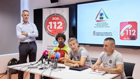El director general de Interior del Gobierno de Navarra, Salva Díez (de pie),  y, en la mesa, de izquierda a derecha, Sergio Ayarra, miembro del Grupo de Rescate Técnico (GRT) de Bomberos de Navarra, Mikel Valdivieso, director de la Escuela Navarra de Montaña y Martín Montañés, presidente de la Federación Navarra de Deportes de Montaña y Escalada