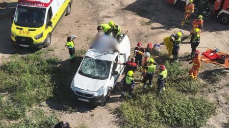 Servicios de emergencia socorren al ciclista, en la baca de la furgoneta