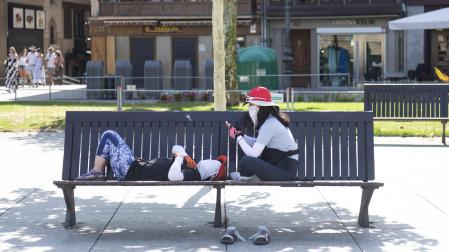 Dos peregrinos descansando en uno de los bancos de la Plaza del Castillo durante la tarde de este miércoles