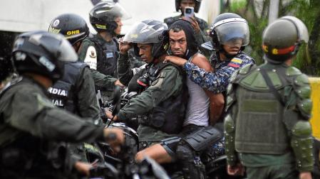 Agentes de la Guardia Nacional Bolivariana se llevan a un detenido en una manifestación en Caracas