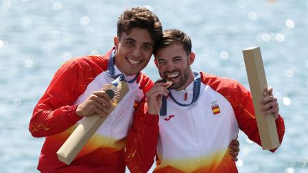 Diego Domínguez y Joan Antoni Moreno muerden en el podio la medalla de bronce conseguida en la modalidad de C2 500 metros del piragüismo