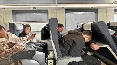 Pasajeros en tren bala hacia Kunming. Algunos aprovechan el trayecto para leer o dormir en posiciones imposibles