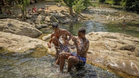Dos jóvenes se refrescan en el río Arga a su paso por Huarte