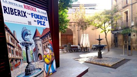 EN LA PLAZA SAN JAIME DE TUDELA Imagen de la portada ‘Riberix y la Fuente del Pez’ que apareció ayer en la plaza San Jaime de Tudela, con la actual fuente al fondo. En la esquina superior derecha, el código QR para acceder a la ficha informativa en la que se explica la historia de la citada fuente