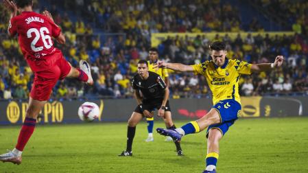 El jugador de la UD Las Palmas Mika Marmol dispara ante el defensa del Sevilla Juanlu