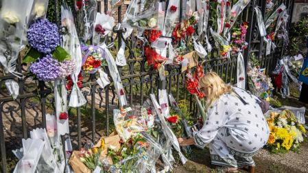 La gente se acerca a deposita flores, fotos y dibujos para rendir homenaje al fallecido actor francés Alain Delon frente a su propiedad en Douchy, Francia