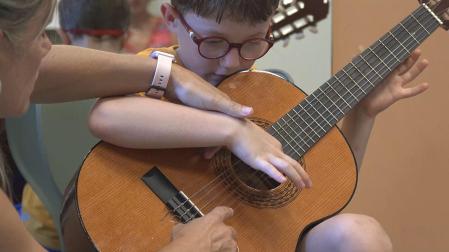 Un niño aprendiendo a tocar la guitarra
