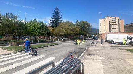 Una persona atraviesa el tramo cortado al tráfico en la calle Ezkaba mientras cambian la señalización