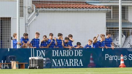Jugadores de las categorías inferiores de Osasuna, viendo un entrenamiento reciente del primer equipo en Tajonar