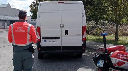 Un agente de la Policía Foral junto al vehículo parado en Ansoáin