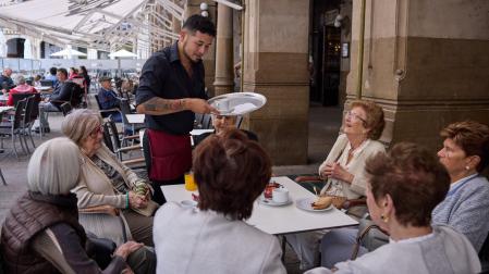 Un camerero le sirve a unas señoras en el Café Iruña