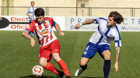 Adrián Salinas, del Artajonés, controla el balón ante Carlos Soroa, de la Mutilvera