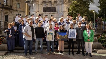 En el centro, el alcalde de Peralta, Juan Carlos Castillo; Zoe Vergara, reina de la Faba 2024 y la alcaldesa de Burlada, Berta Arizkun. Con ellos, el coro de Muthiko Alaiak y personas de la Junta de la peña.