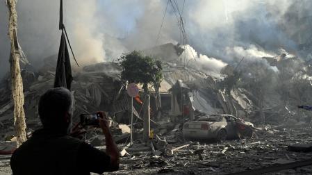 Un hombre fotografía un edificio derrumbado después de un ataque aéreo israelí sobre el barrio de Dahieh, uno de los bastiones de Hizbulá, en Beirut (Líbano)