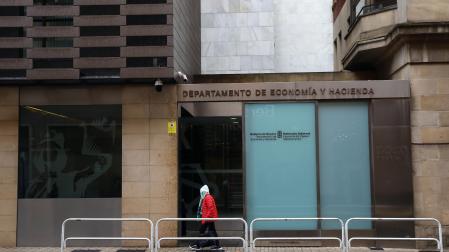 Una persona camina ante la sede del departamento de Economía y Hacienda