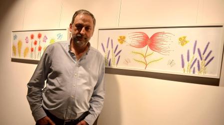 El artista navarro Nacho Barberena posa delante de sus cuadros con flores muy bellas que intentan atraer a las mariposas... a la muerte