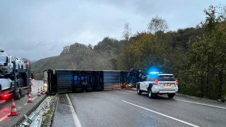 El camión accidentado, volcado sobre la vía