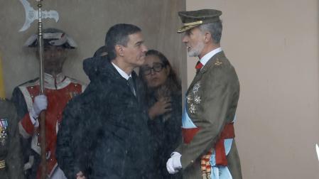 El rey Felipe VI conversa con el presidente del Gobierno, Pedro Sánchez (i), este sábado, en el marco del tradicional desfile del Día de la Fiesta Nacional por el Paseo del Prado de Madrid